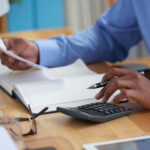 Man calculation company income tax using the tax preparation in Nigeria Guide by Taxanchor360